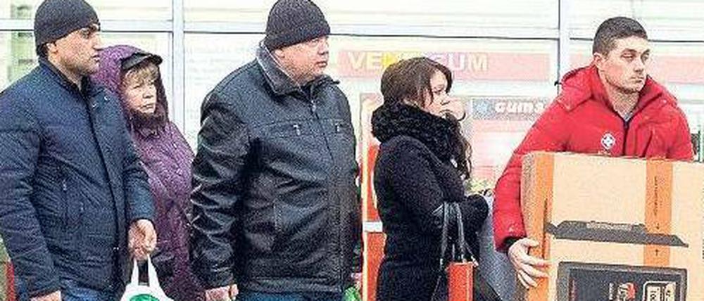 Schlange stehen. Weil die Russen um den Wert des Rubels fürchten, plündern viele ihre Konten, um einkaufen zu gehen.