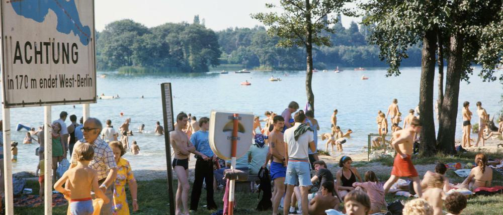 "Achtung, in 170 m endet West-Berlin": Mitten durch den Groß-Glienicker See verläuft die Grenze zur DDR. Am gegenüberliegenden Ufer sind Grenzbefestigungen zu sehen. Das hält die West-Berliner nicht von ihren Badefreuden ab (undatierte Aufnahme). Heute sieht es anders aus.