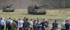 Journalisten beobachten ein Manöver von Panzerhaubitzen 2000. 