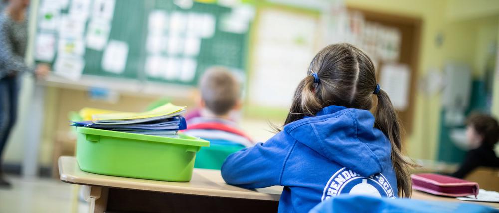 Schülerinnen und Schüler einer Grundschule sitzen in ihrem Klassenraum.