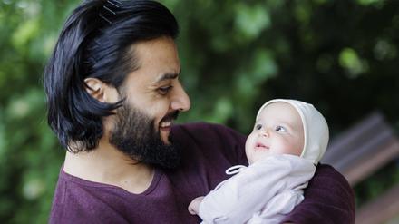 Vater strahlt sein Baby an.