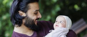 Vater strahlt sein Baby an.