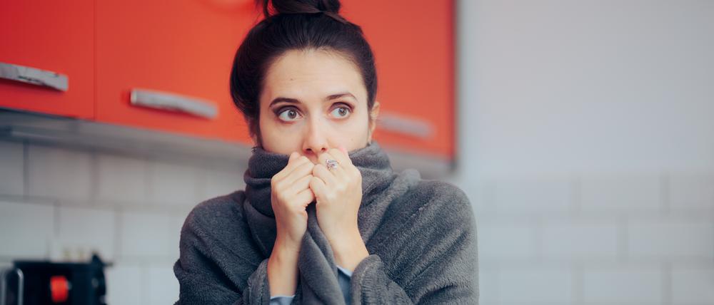 Young adult freezing in the apartment because of energy crisis and power cuts
