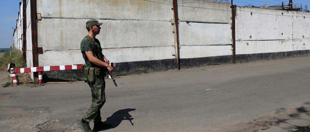 Ein Soldat steht Wache neben der Mauer eines Gefängnisses in Oleniwka, in einem von Russland kontrollierten Gebiet. Russland und die Ukraine beschuldigten sich am gegenseitig, ein Gefängnis in einer separatistischen Region der Ostukraine beschossen zu haben.
