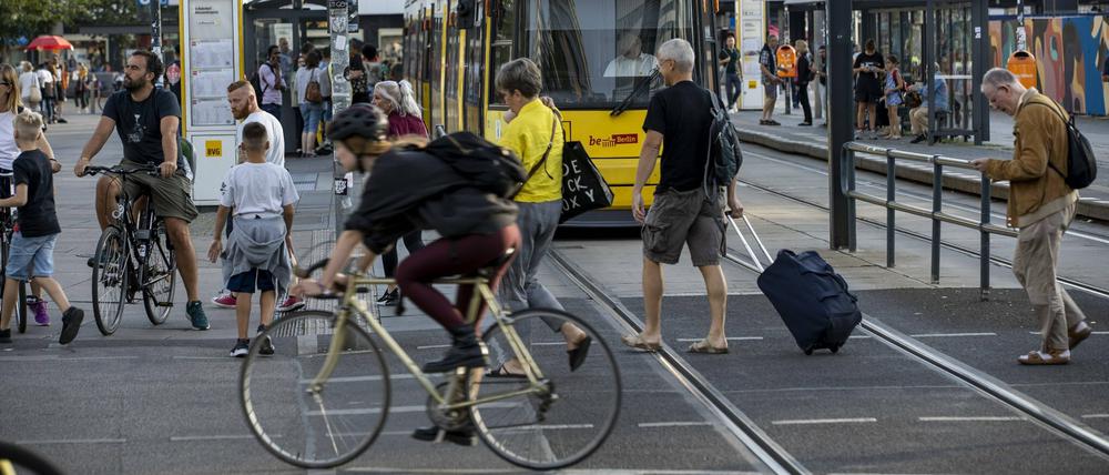 Passanten, Radfahrer und Straßenbahnen teilen sich den Alexanderplatz.