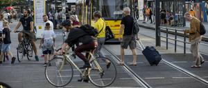 Passanten, Radfahrer und Straßenbahnen teilen sich den Alexanderplatz.