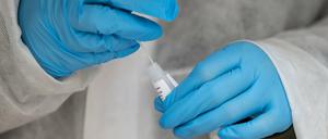 Eine Mitarbeiterin einer Teststation führt einen Corona-Schnelltest durch.