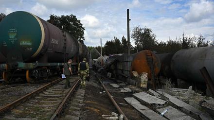 Militärangehörige besichtigen ausgebrannte Waggons im von prorussischen Truppen besetzen Teil von Donezk.