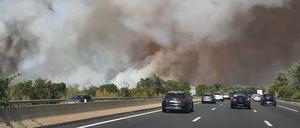 Frankreich, Aubais: Dichter weißer Rauch steigt neben einer Autobahn von einem Waldbrand auf.