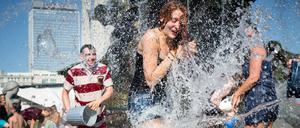 Jugendliche machen eine Wasserschlacht im Neptunbrunnen vor dem Roten Rathaus.