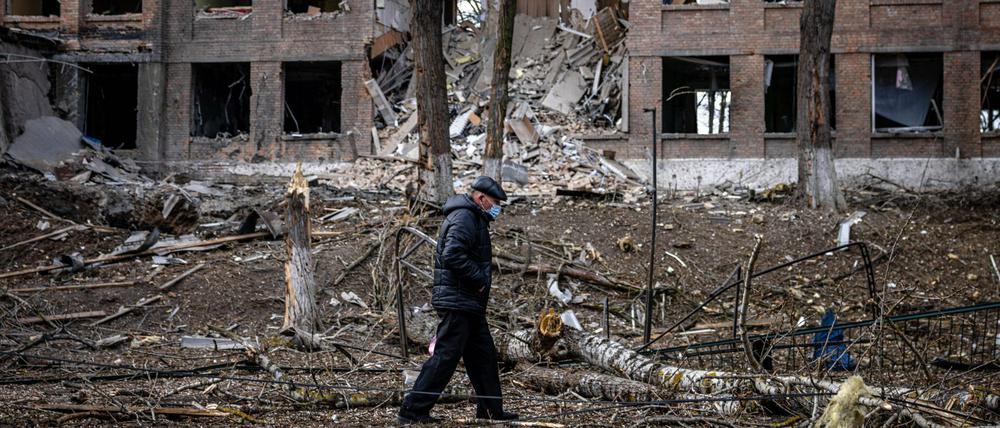 Nach einem russischen Raketenangriff im Februar schlendert ein Mann durch einen Kiewer Vorort.