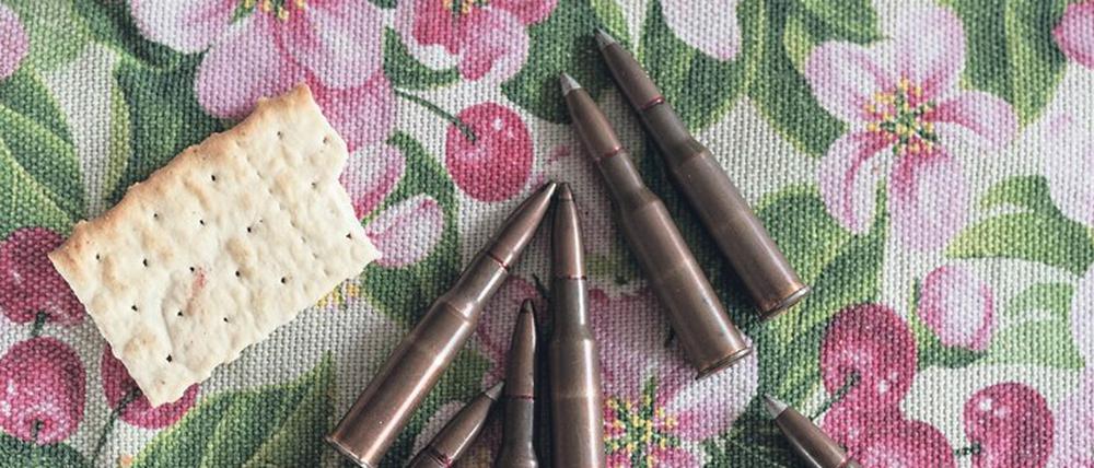 Knäckebrot und Patronen auf einer Tischdecke in der Küche eines ukrainischen Mannes.