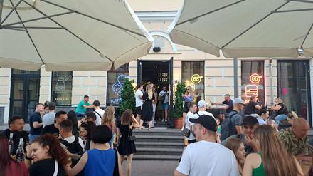 Menschen gehen im Stadteil Podil aus und genießen Getränke.