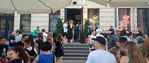 Menschen gehen im Stadteil Podil aus und genießen Getränke.