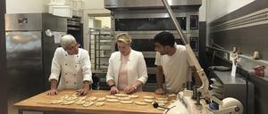 Bäckermeisterin Christa Lutum (li.) zeigt Franziska Giffey die Kunst des Brezel-Backens.