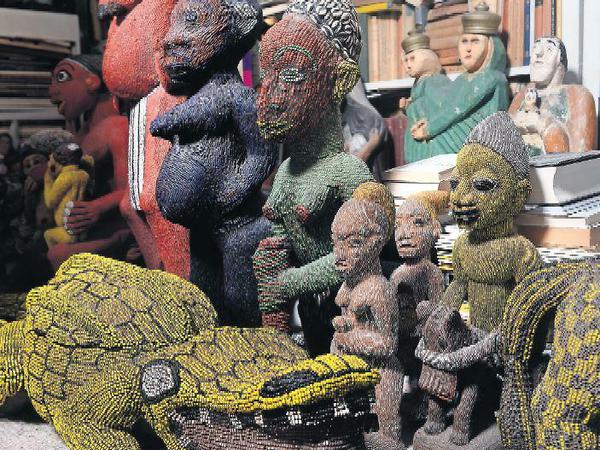 Kamerunische Holzstatuen vor der Büchersammlung.