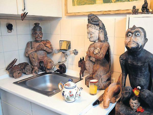 Spülbecken, mit Statuen zugestellt plus Teekanne, die kein Ausstellungsstück ist.