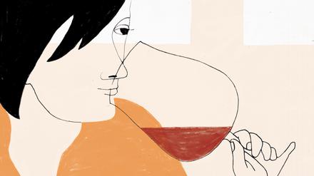 Frau riecht an einem Rotweinglas.