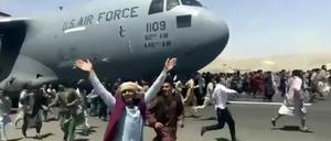 Hunderte Menschen laufen am 16. August 2021 neben einer Boeing C-17 der amerikanischen Luftwaffe in Kabul.