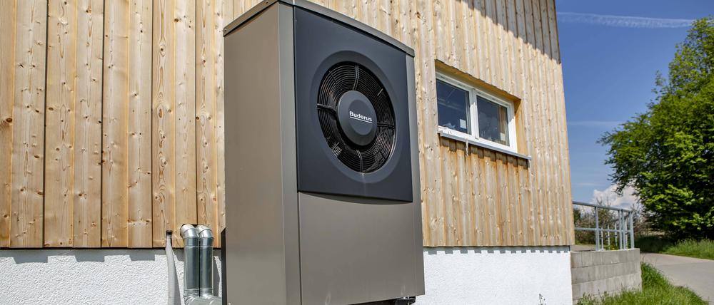 Ein Wärmepumpe des Herstellers Buderus steht an einem Haus.