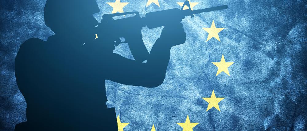 Der Schattenriss eines Soldaten vor einer blauen Europaflagge mit dem Kranz gelber Sterne.