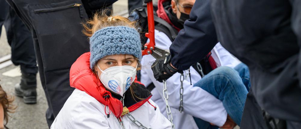 Nana-Maria Grüning während einer Blockade: Die Polizei zerschneidet die Kette, mit der sich Scientist Rebellion aneinandergekettet haben. 