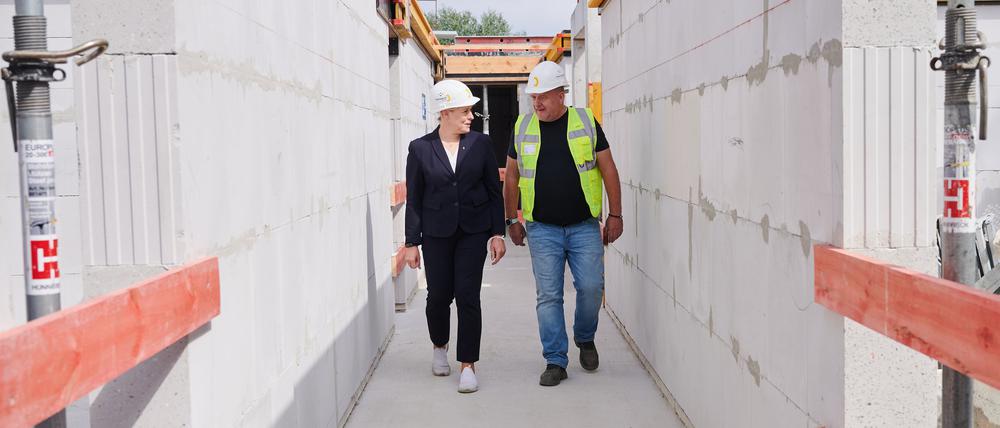 Franziska Giffey (SPD), Regierende Bürgermeisterin von Berlin, geht mit Mario Fröhlich, Bauleiter, auf dem Dach eines Neubaus der WBM Wohnungsbaugesellschaft.