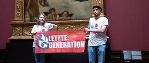 Zwei Umweltaktivisten der Gruppe „Letzte Generation“ stehen mit einem Banner in der Gemäldegalerie Alte Meister (Archivbild).