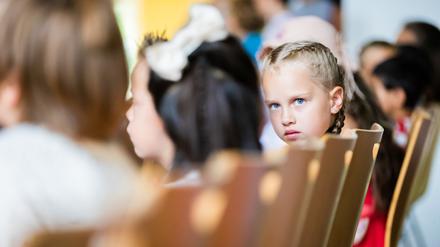 27.08.2022, Berlin: Die 6-jährige Yeva aus der Ukraine verfolgt bei ihrer Einschulung die Einschulungszeremonie in der Tempelherren-Grundschule im Berliner Stadtteil Tempelhof. Yeva ist mit ihrer Mutter Yuliia aus der westlich von Kiew gelegenen Stadt Schytomyr nach Berlin geflohen und privat bei einer Familie untergekommen. In der Tempelherren-Grundschule wurden insgesamt drei Kinder aus der Ukraine eingeschult. Foto: Christoph Soeder/dpa - ACHTUNG: Nur zur redaktionellen Verwendung im Zusammenhang mit der aktuellen Berichterstattung und nur mit vollständiger Nennung des vorstehenden Credits +++ dpa-Bildfunk +++