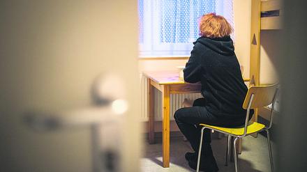 Eine Frau blickt in einem Berliner Frauenhaus aus dem Fenster. 