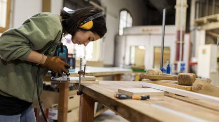  Craftswoman working with router jig at workbench in workshop model released Symbolfoto property released VABF04268