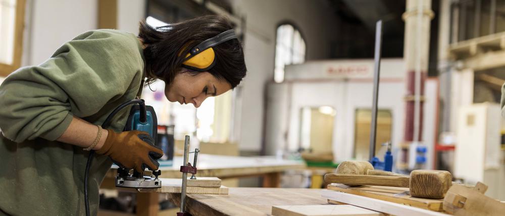  Craftswoman working with router jig at workbench in workshop model released Symbolfoto property released VABF04268