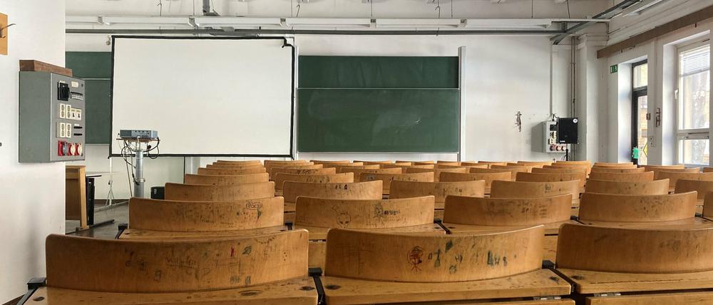 Ein leerer Hörsaal mit heruntergekommener Bestuhlung.