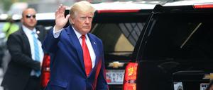 Der Ex-US-Präsident Trump steigt in New York in ein Auto und winkt. 