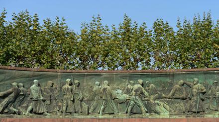 Das Tiegelgussdenkmal in der ThyssenKrupp-Allee in Essen. Das rot-ummauerte langgezogene Relief stellt die Arbeitsschritte bei der Stahlherstellung im 19. Jahrhundert dar.
