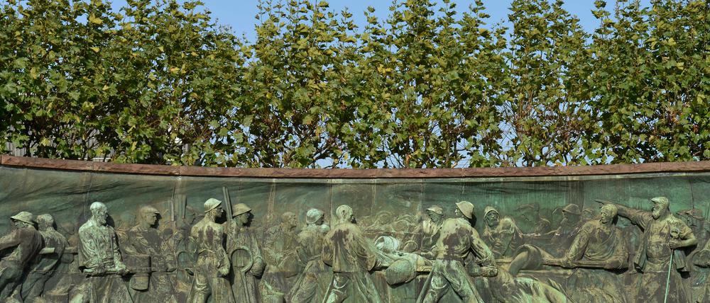 Das Tiegelgussdenkmal in der ThyssenKrupp-Allee in Essen. Das rot-ummauerte langgezogene Relief stellt die Arbeitsschritte bei der Stahlherstellung im 19. Jahrhundert dar.