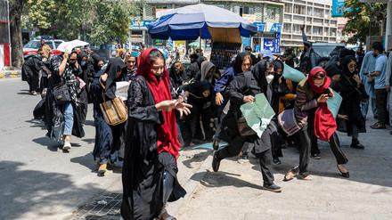 Protestierende Frauen in Kabul flüchten, nachdem Warnschüsse gefallen sind.