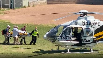 Salman Rushdie wird auf einer Trage zu einem Hubschrauber gebracht.