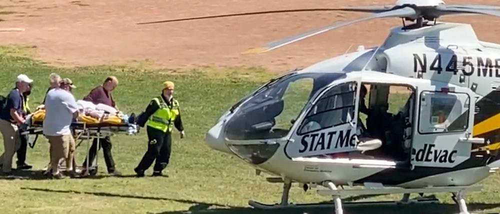 Salman Rushdie wird auf einer Trage zu einem Hubschrauber gebracht.