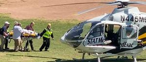 Salman Rushdie wird auf einer Trage zu einem Hubschrauber gebracht.