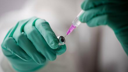 Eine Mitarbeiterin zieht eine Spritze mit dem Impfstoff von Biontech auf. 