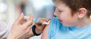 Ein Kind bekommt eine Impfung in den Oberarm.