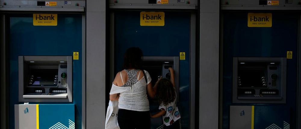 Eine Griechin hebt am Automaten Geld ab. Die Finanzen des Landes werden künftig nicht mehr durch die EU überwacht.