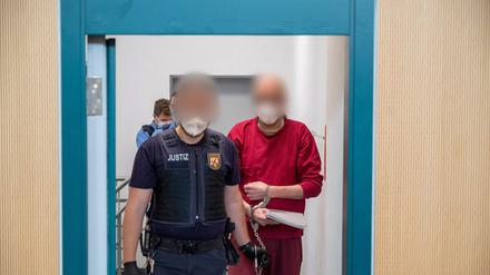 Ein Justizbediensteter begleitet den 52-jährigen Angeklagten (r) zum Prozess um die tödliche Amokfahrt in Trier. 