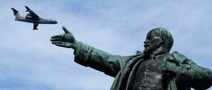 Ein Militärflugzeug fliegt über einer Lenin-Statue am Himmel. In Estland werden sowjetische Denkmäler künftig nicht zu sehen sein.