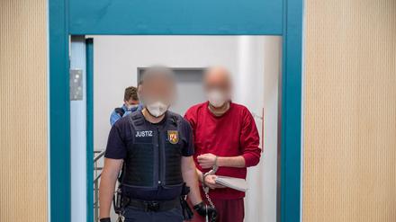 in Justizbediensteter begleitet den 52-jährigen Angeklagten zum Prozess um die tödliche Amokfahrt in Trier in den Gerichtssaal.