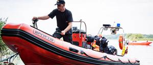 Feuerwehrleute in einem Boot ziehen bei Stettin tote Fische aus der Oder. Seit mehr als einer Woche beschäftigt das massive Fischsterben im Fluss die Behörden und Anwohner.