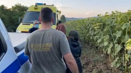 Ein griechischer Grenzpolizist mit Migranten in der Nähe des Flusses Evros.