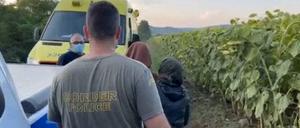 Ein griechischer Grenzpolizist mit Migranten in der Nähe des Flusses Evros.