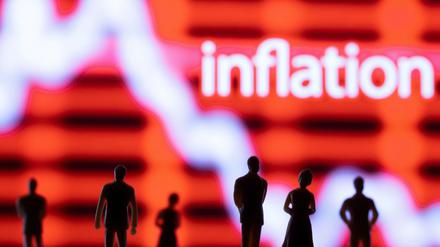 Plastikfiguren stehen vor einem Kurvenverlauf der mit "Inflation" gekennzeichnet ist.